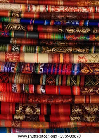 Handmade blankets in a variety of colors and designs for sale at the outdoor craft market in Otavalo, Ecuador
