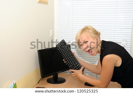 Angry business woman in office with computer