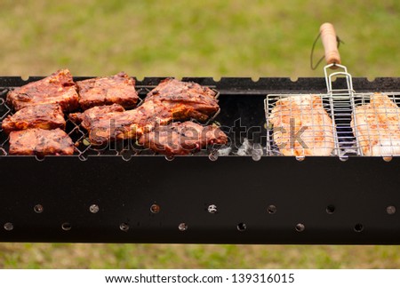 BBQ Ribs and fish  on grill with charcoal.