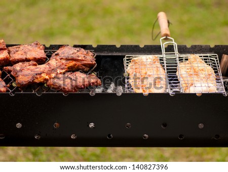 BBQ Ribs and fish  on grill with charcoal.