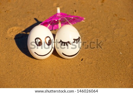 easter funny eggs under umbrella on a beach.