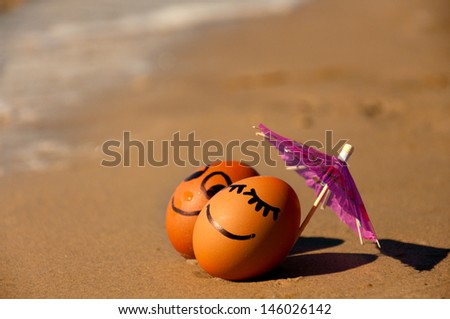 easter funny eggs under umbrella on a beach.