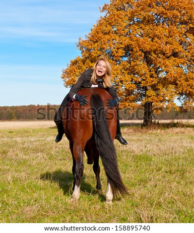 beautiful woman walking with horse.Woman smiling and holding horse butt.