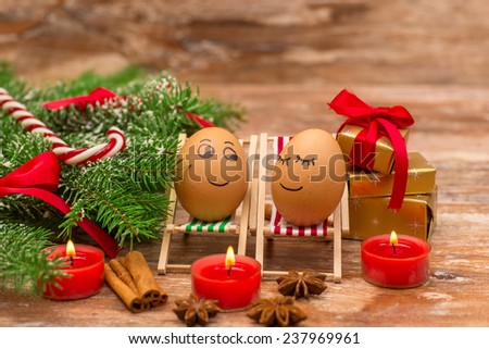 funny eggs on a beach chairs, Christmas tree, mandarine, gift and candles.  christmas background theme