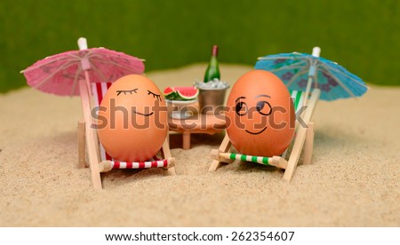 easter funny eggs sitting on a chair under umbrella on a sand and bottle of champain in a  bucket with watermelon. selective soft focus