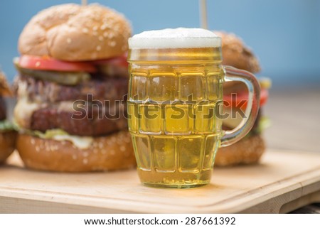 Tasty grilled burger and glass of cold beer. tasty summer symbol. Selective focus