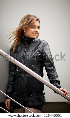 Beautiful girl on a lighter background of the wall. The girl draws a little shiny pipe is blocked