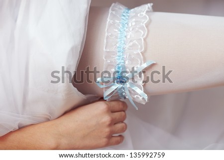 The bride wears a wedding garter on the leg