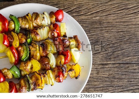 Healthy barbecued lean cubed pork kebabs on old wood table