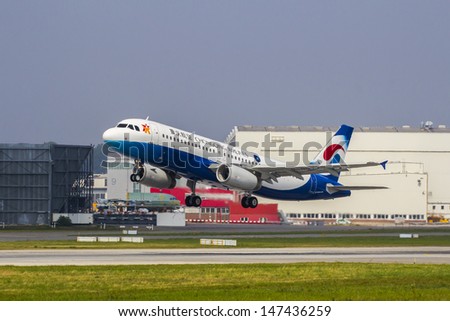 HAMBURG, GERMANY - JULY 25: Take Off of a brand new Airbus A320 for chinese regional carrier Chongqing Airlines on delivery flight from the Airbus Plant in Hamburg Finkenwerder on July 25, 2013