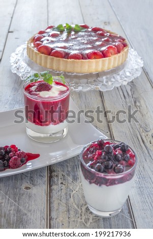 Collection of summer desserts with mixed berries yoghurt, raspberry cream and strawberry cake