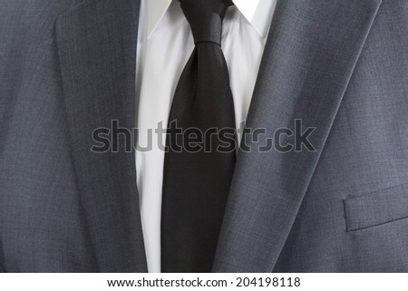 Detail of a man wearing a suite with white shirt and black tie