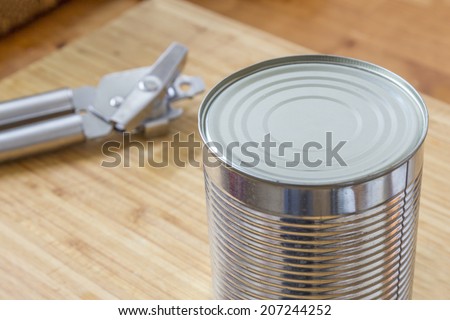 A Silver Can with a can opener on a wooden table in the kitchen
