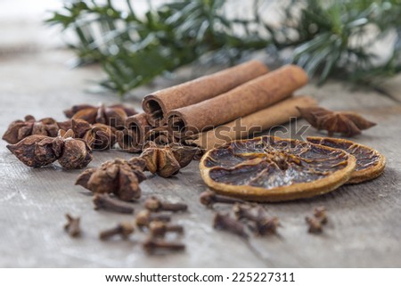Fir Cone and a needle branch with cinnamon sticks as decotration on a white wooden table