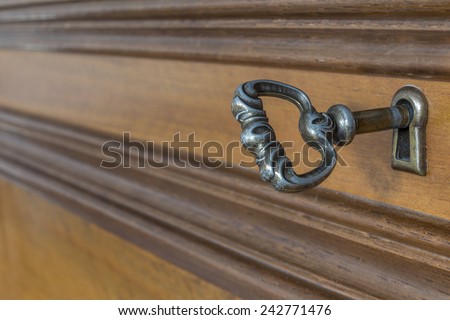 Ancient key in the keyhole of antique furniture