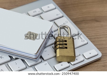 Batch of Credit or debit Cards with a combination lock on a modern silver keyboard