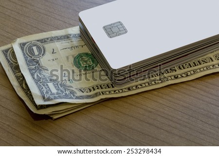 A Batch of Credit or Debit Cards and a couple of dollar notes on a wooden table