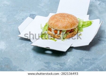 Chicken Burger in an open box on metal background
