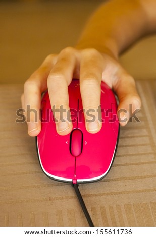 Pink mouse controlled by child\'s hand