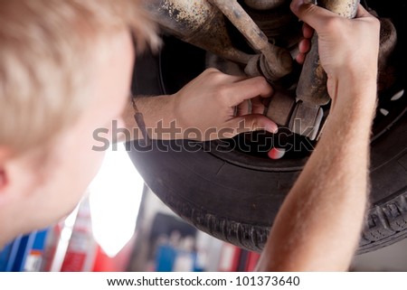 A mechanic inspecting a shock absorber on a car