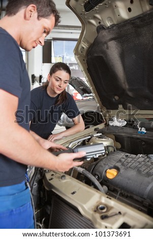 Two mechanic workers with diagnostics tool