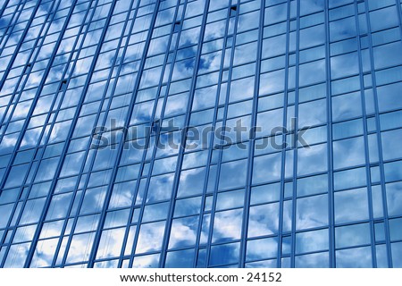 A downtown sky scraper reflecting a blue sky and clouds.