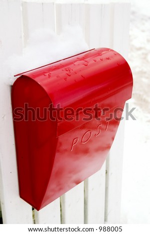 A retro mail box hanging on a white picket fence in Oslo Norway