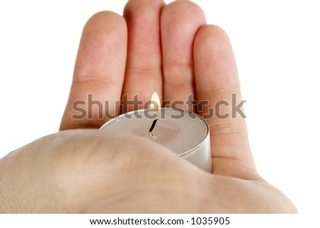 A simple tea light candle being held in a hand, isolated on white with clipping path.