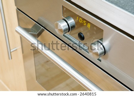 A modern stainless steel oven detail showing the knobs and door