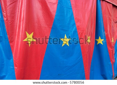 A circus tent with red and blue triangles and yellow stars.