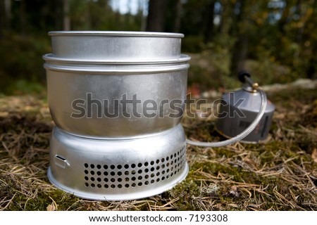 A camp stove cooking water in the forest with pressurized gas