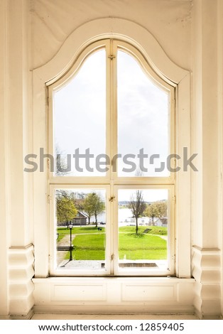 An old arched window view out to a garden