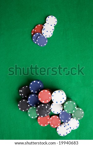 A large stack of poker chips on a green felt