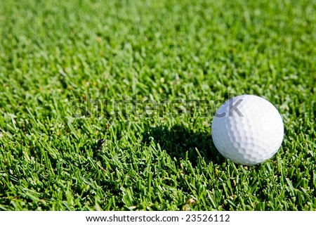 A golf ball sitting on green grass - background image