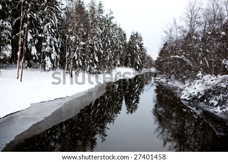 A cold winter river with a grey sky