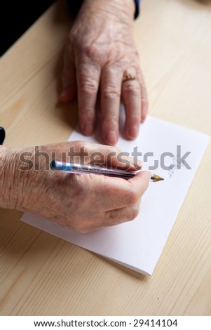 An old pair of hands writing a letter