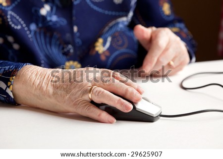 An elderly hand on a computer mouse