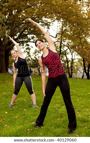 A group of people stretching in a park - focus on front woman