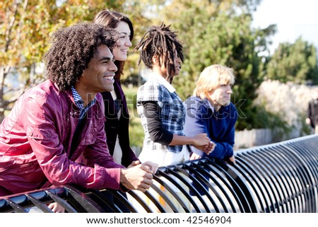 A group of friends outside in a park having fun - shallow depth of field with sharp focus on first person