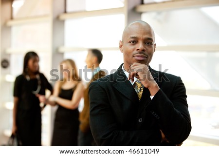 An African American business man with co-workers in the background
