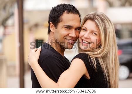 stock photo : A happy couple hugging and looking at the camera