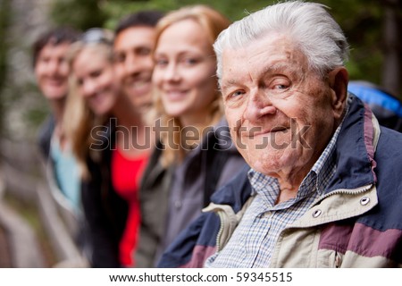 An elderly man in front of a group of young people