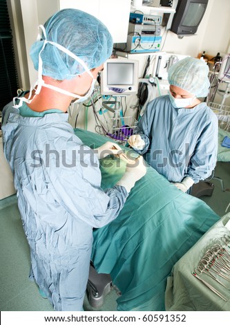 A team doing surgery in a small operating room