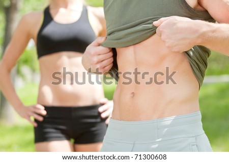 Sexy man showing his six-packs while woman standing in background
