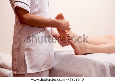 A professional masseur giving a foot massage in a spa