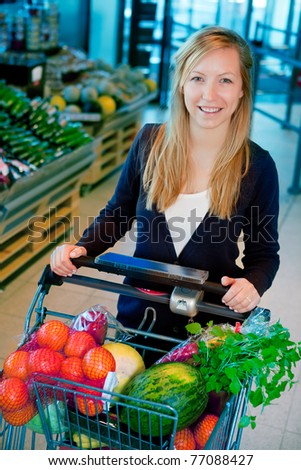 A portrait of a happy female shopper in a supermarket