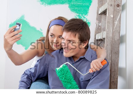 Young happy couple taking a snapshot of themselves with cellphone
