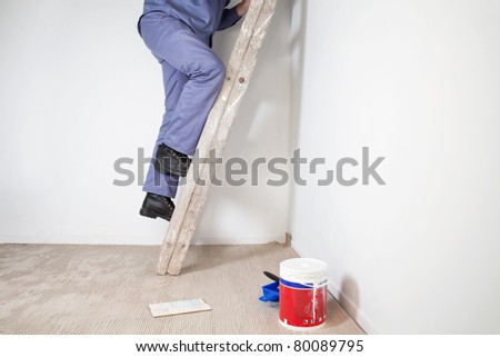 Low section of man\'s legs climbing wooden ladder