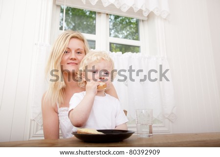 Portrait of a mother and son sitting at a table eating lunch together