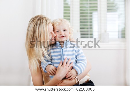 Young beautiful mother hugging baby boy from behind